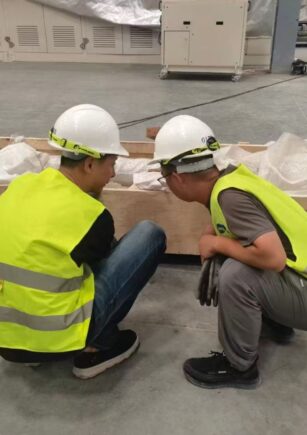 Engineers and operators discussing a grinding line beside the machine