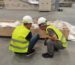 Engineers and operators discussing a grinding line beside the machine