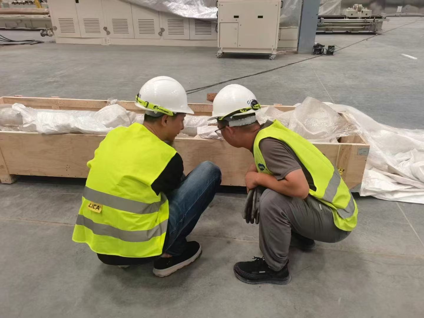 Engineers and operators discussing a grinding line beside the machine